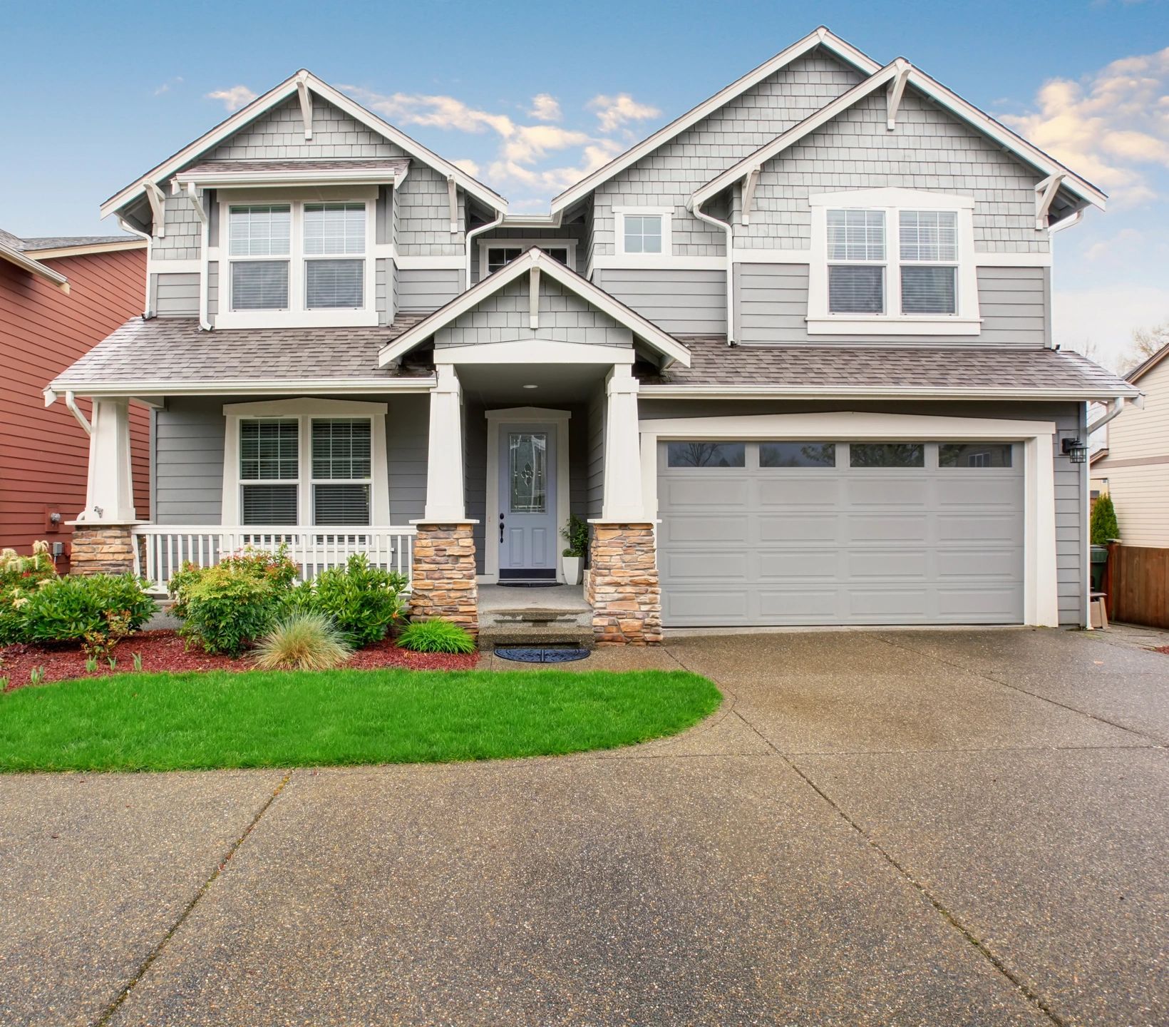 A house with a driveway and lawn in front of it.