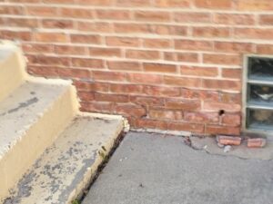 A brick wall with a hole in the middle of it